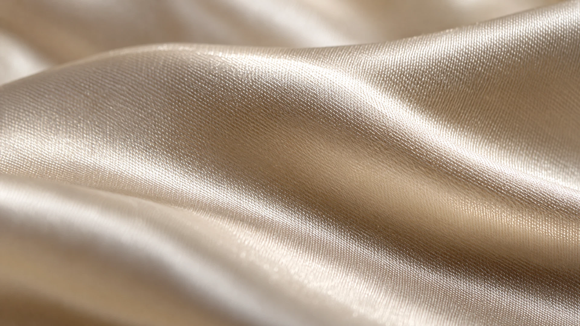 Extreme macro photograph of mulberry silk charmeuse, showing the fine diagonal weave and a long soft sheen across the surface.